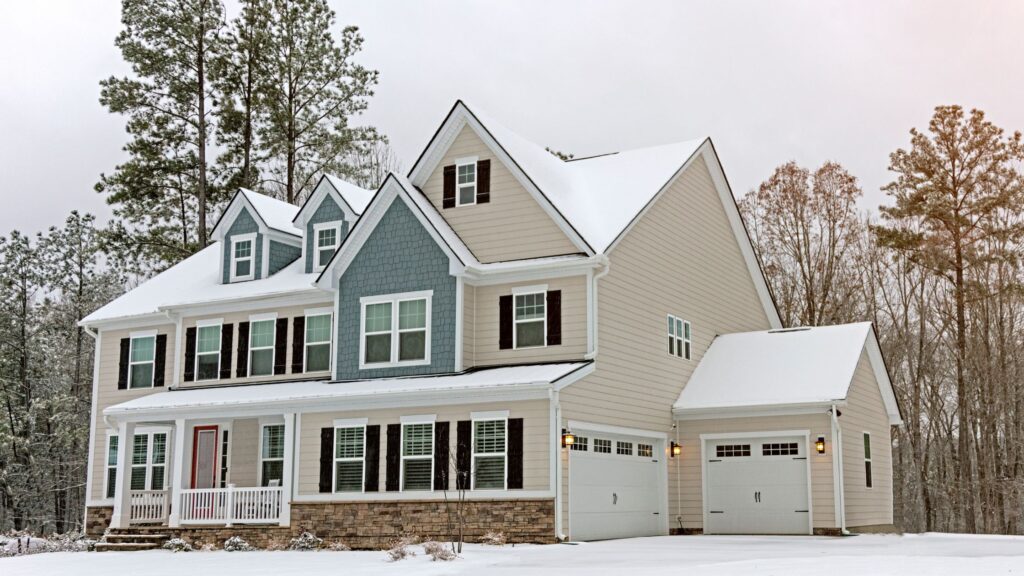 A modern two-story Winnipeg home in winter featuring snow-covered roof and energy-efficient windows, showcasing window styles for maximum insulation.