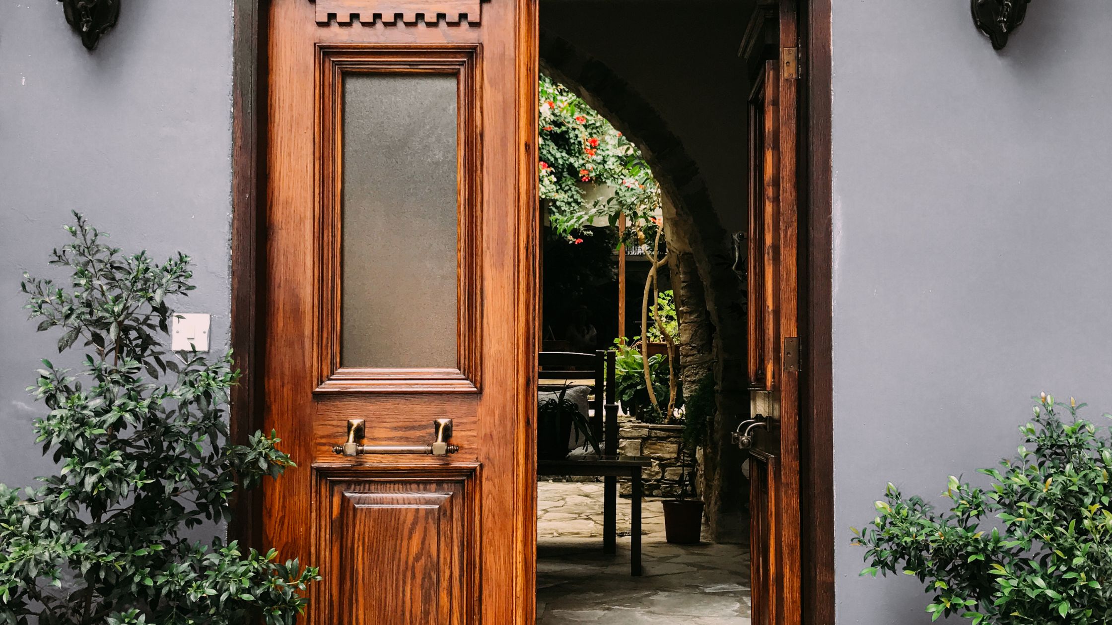 Wooden front door slightly open with visible wear, showcasing one of the Signs Your Door Needs Replacement in Winnipeg homes.